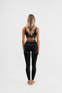 Être Noir et Blanc crne tajice i sportski grudnjak s bijelim prugama - stražnja strana, premium ženska sportska odjeća