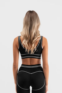 Detalj crnog Être Noir et Blanc Topa back- bijele kontrastne pruge i šavovi, premium ženska sportska odjeća
