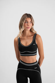 Detalj crnog Être Noir et Blanc Topa - bijele kontrastne pruge i šavovi, premium ženska sportska odjeća