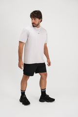 Muškarac u Être Active Light Gray svijetlo sivoj majici s malim logom, crne sportske kratke hlače i crne Être čarape s bijelim prugama - kompletni muški sportski outfit, bočni pogled, indoor studio fotografija, casual athleisure styling