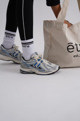 Être bijele sportske čarape i bež tote bag platnena torba - lifestyle fotografija s crnim Etre Noir et Blanc tajicama, premium accessories styling