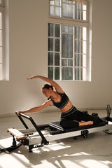 Crni Noir et Blanc set Être s bijelim prugama - sports bra i leggings na pilates reformeru, stretching vježba, indoor studio, premium sportska odjeća