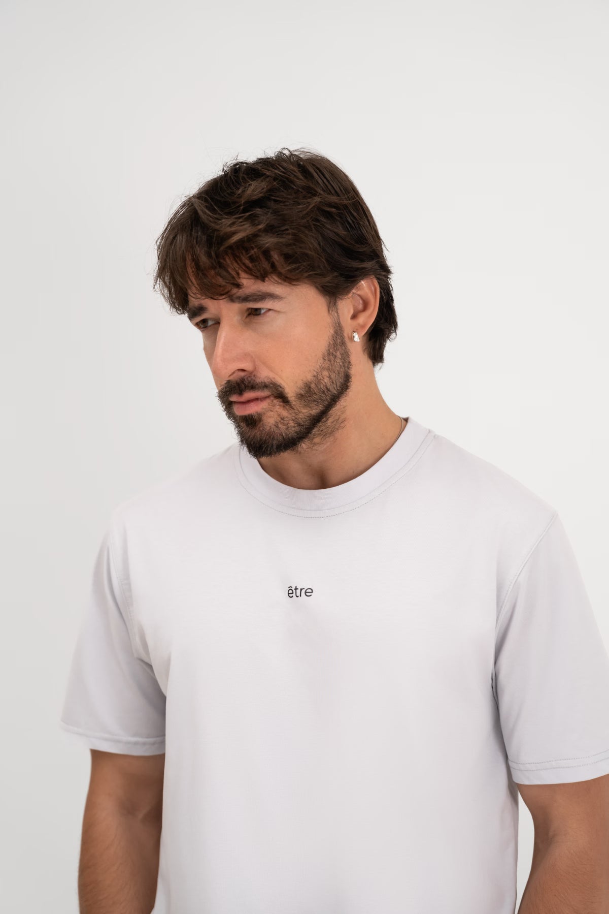 Muškarac u Être Active Light Gray svijetlo sivoj majici s malim smeđim 'être' logom na prsima - prednji pogled, okrugli ovratnik, indoor studio fotografija, unisex casual sportska majica