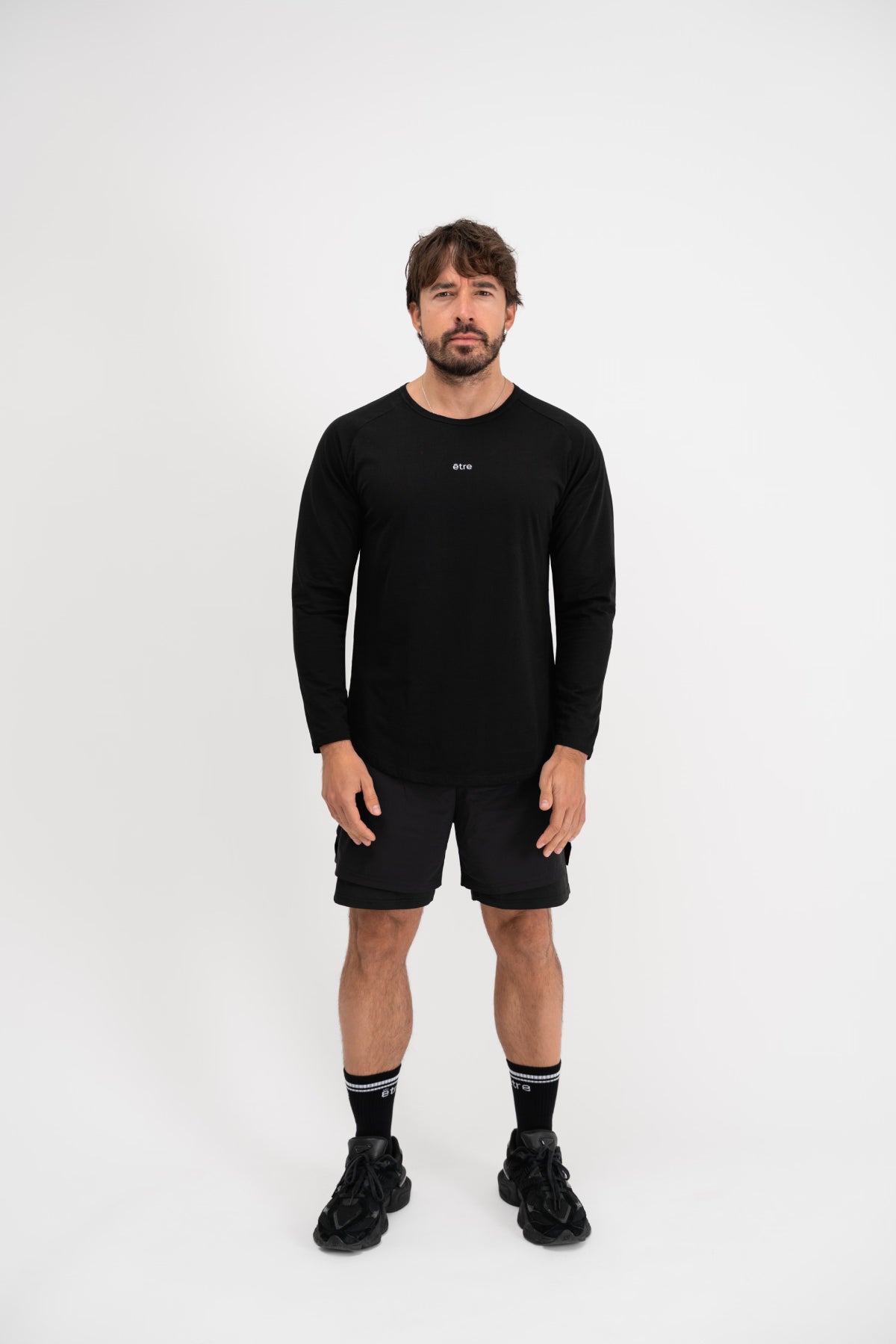 Muškarac u crnoj Urban Black majici Être s dugim rukavima - cijeli outfit, casual sportski stil