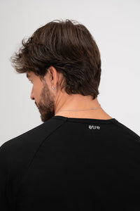 Crna unisex majica Urban Black Être - stražnji pogled s logom na vratu, dugi rukavi, premium casual odjeća